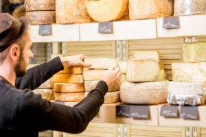 person stacking cheese wheels